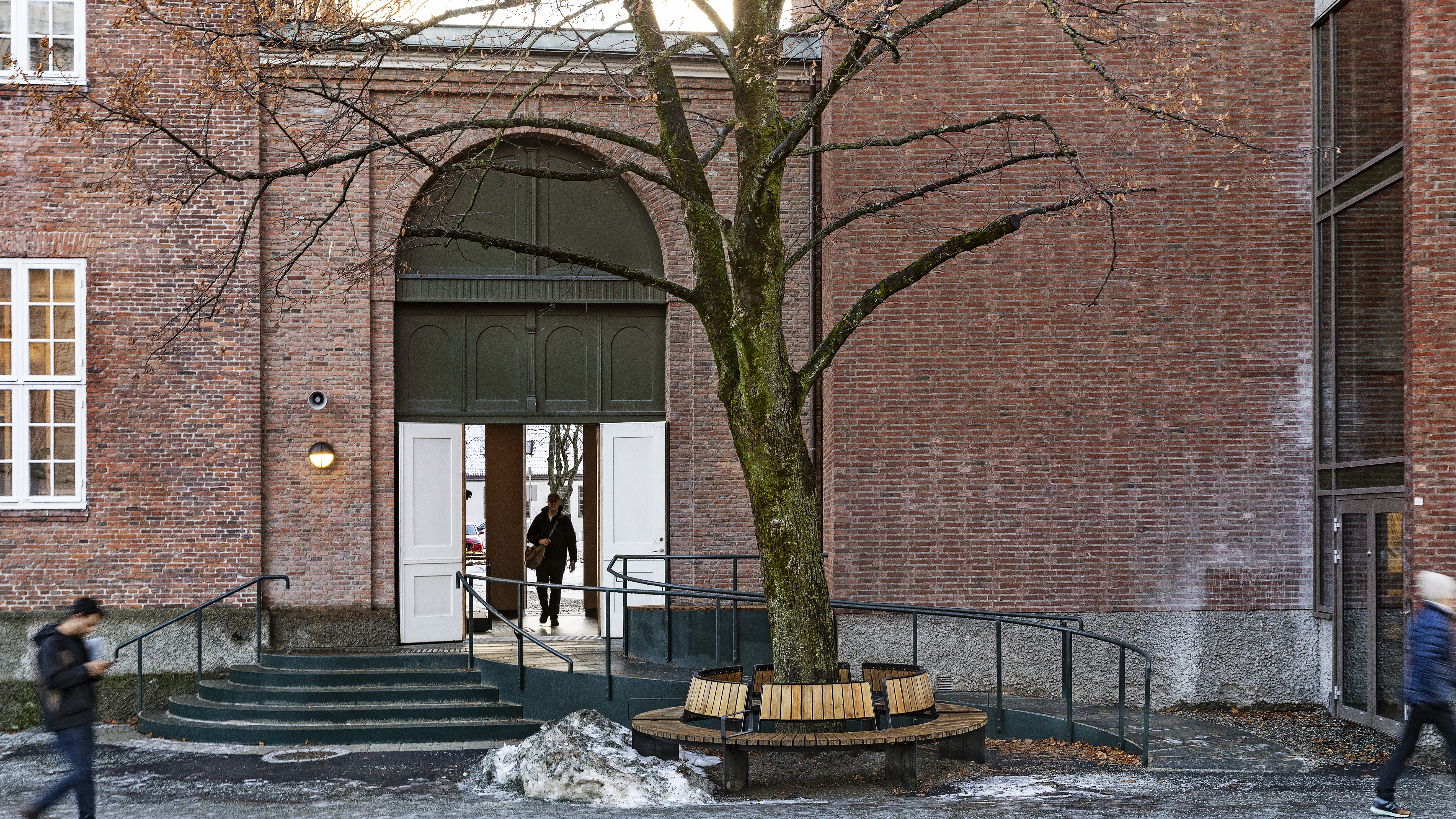 Rampe og trapp foran passasje/portrom mellom to bygninger i tegl