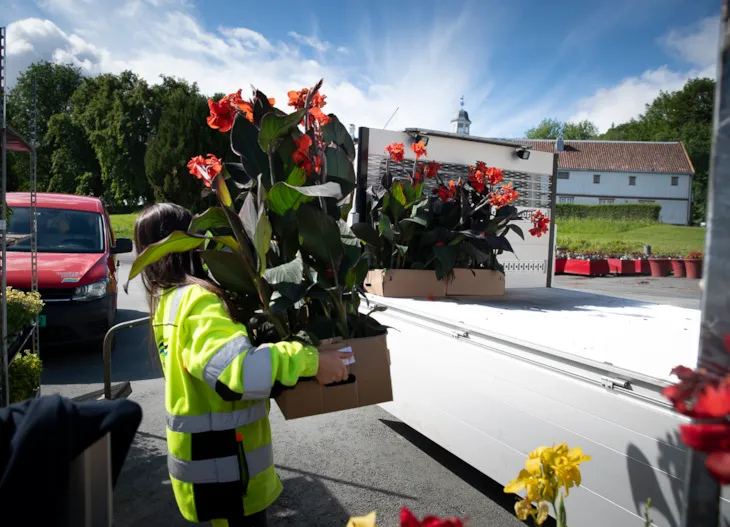 Cristina b&aelig;rer planter bort til lasteplanet p&aring; en lastebil.