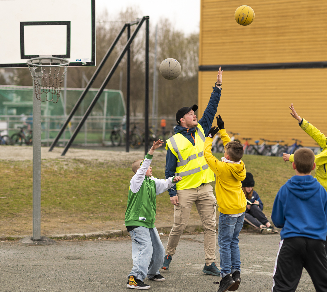 Kontaktl&aelig;rer Sondre Brekke Valmork som spiller basketball med barn i skoleg&aring;rden