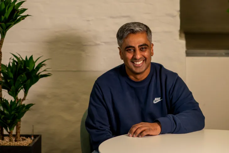 Innendørs portrett av prosjektleder Gnanavalluvan Vettivel i sivilt tøyforan en murvegg.