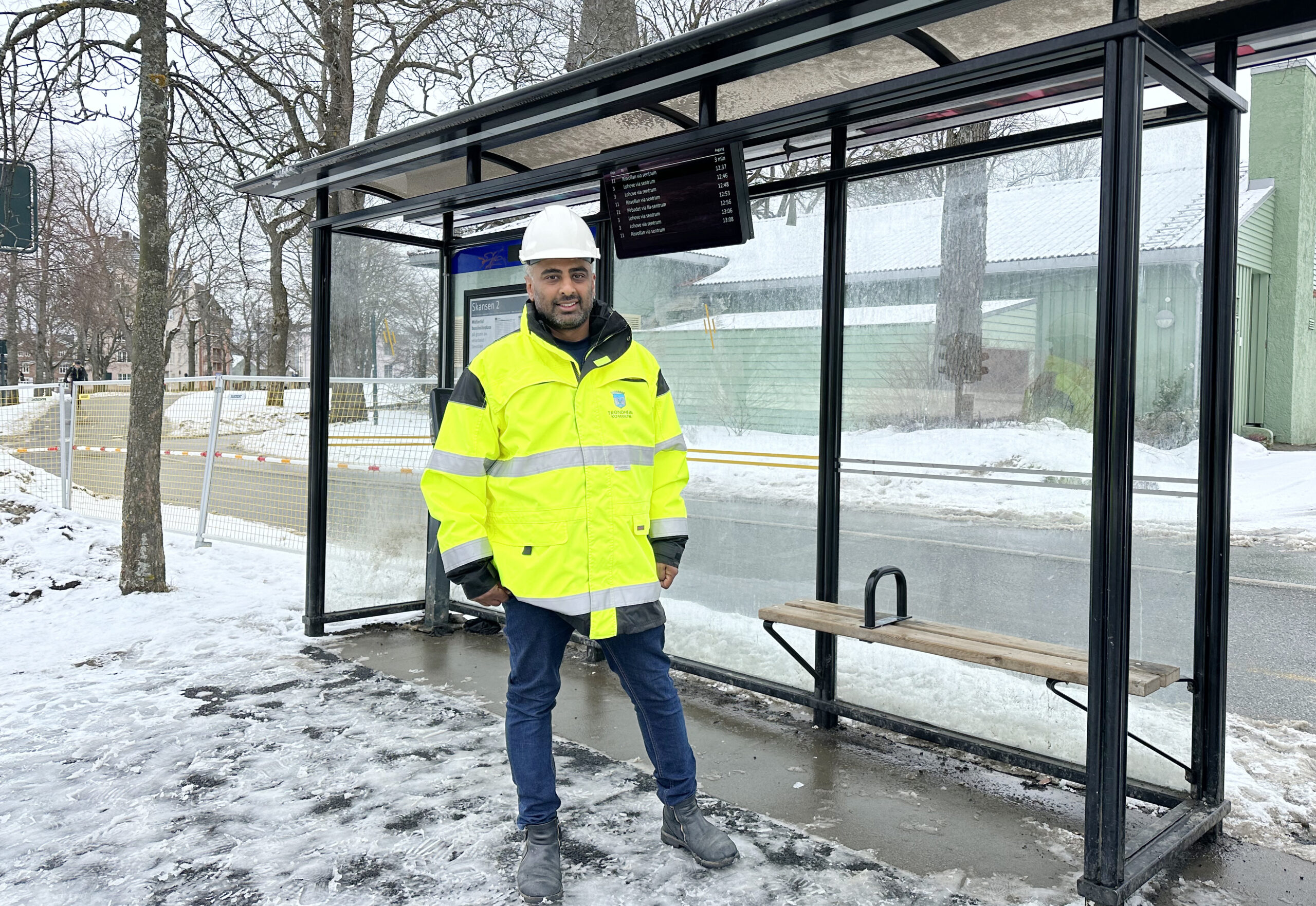 Mann stående foran busskur