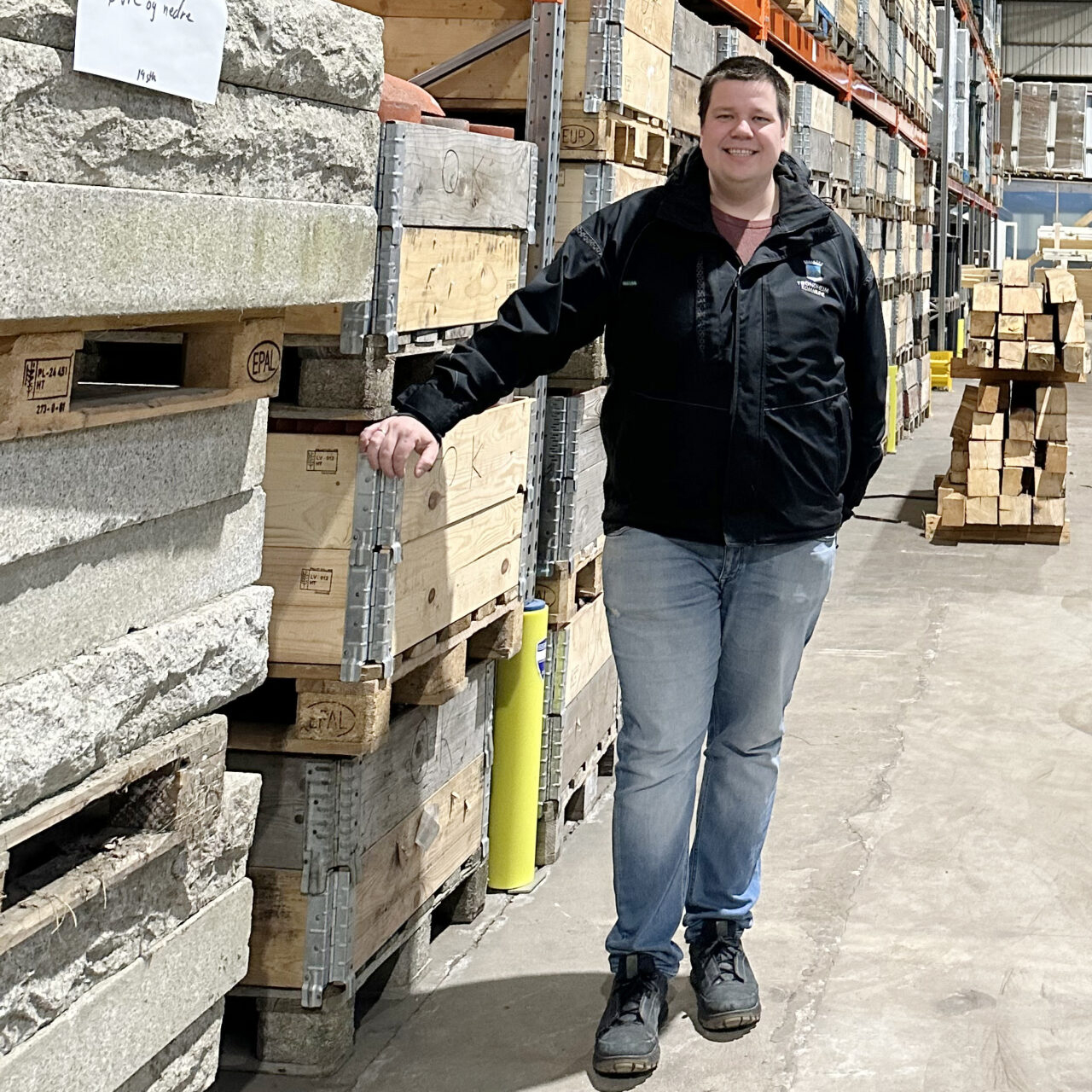 Mann st&aring;ende ved siden av steinlager