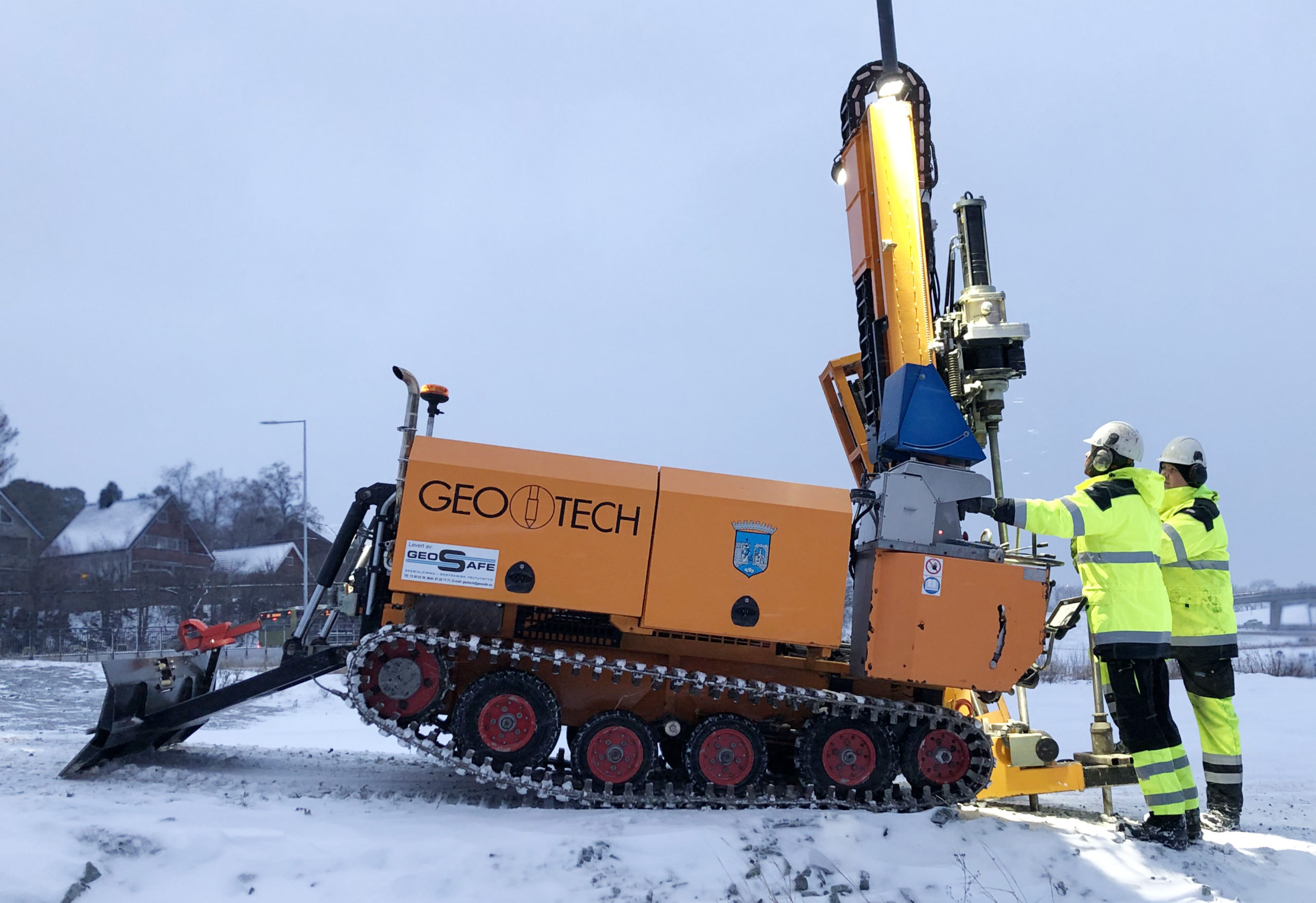 Boremaskin med to menn ved siden av