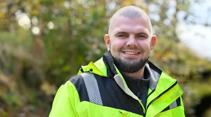 Portrett av arbeidsleder Andreas Foss Pedersen foran grønt buskas