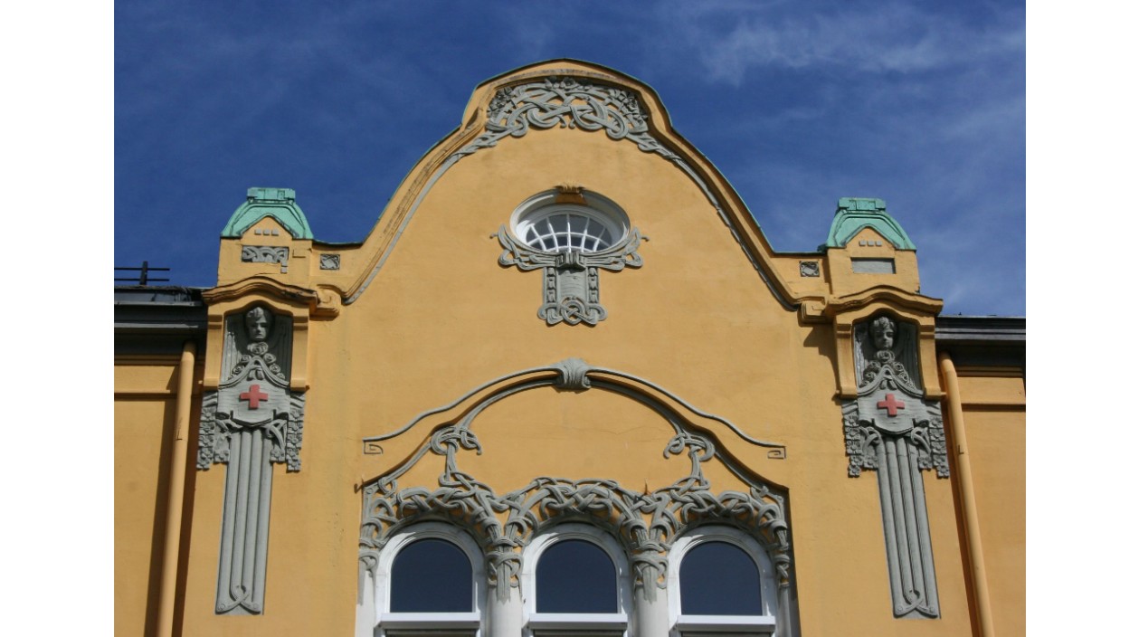 Pusset murfasade med detaljer i naturstein