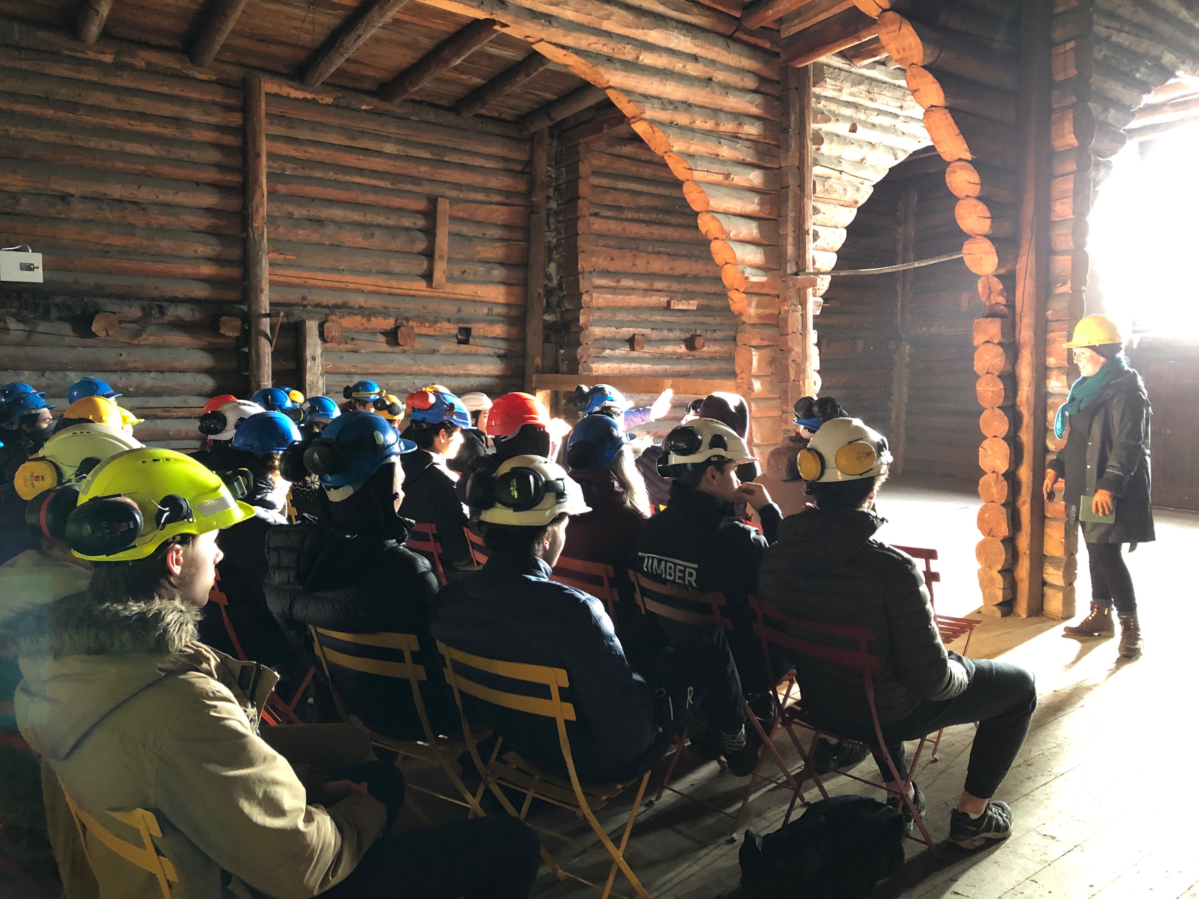 Folk i arbeidskl&aelig;r i hjelmer sitter p&aring; stoler