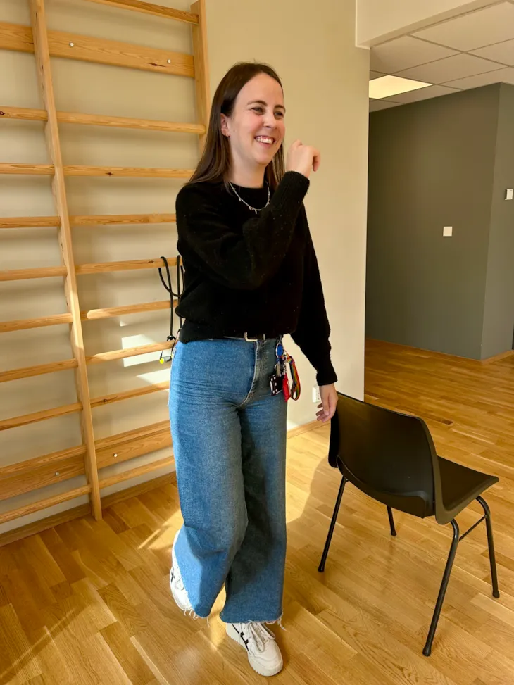 fysioterapeut viser øvelse der hun står på en fot og pusser tenner