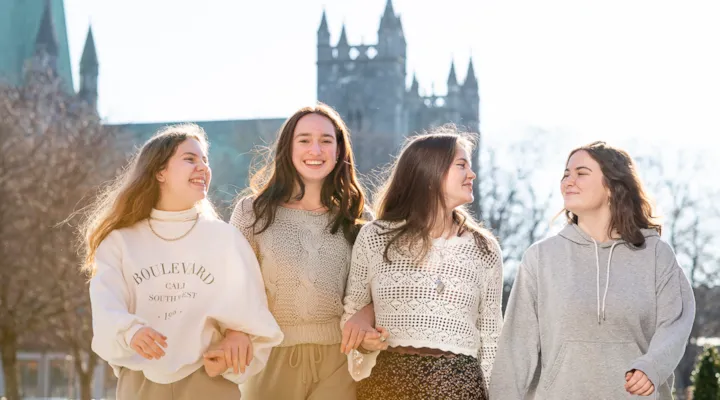 Fire medelever foran Nidarosdomen i sollys.