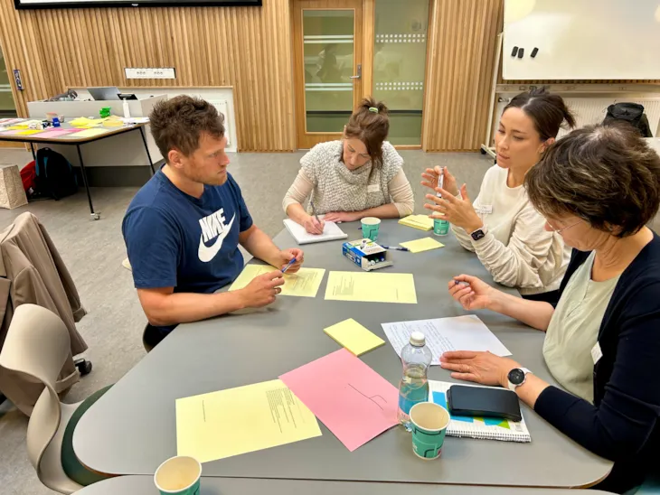 ansatte ved NTNU, Trondheim kommune og St.Olavs hospital sitter rundt et bord og jobber med oppgaver