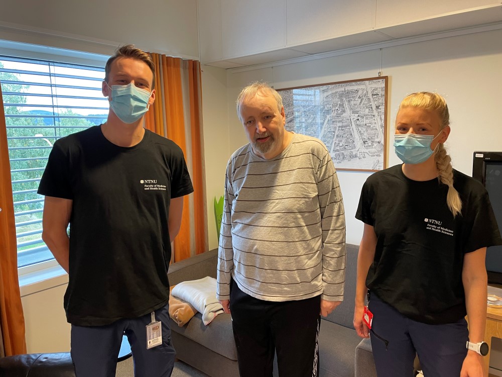 Bilde av Vemund Øvstehage og Stine Øverengen Trollebø fra NTNU sammen med beboer Johan Schelvan