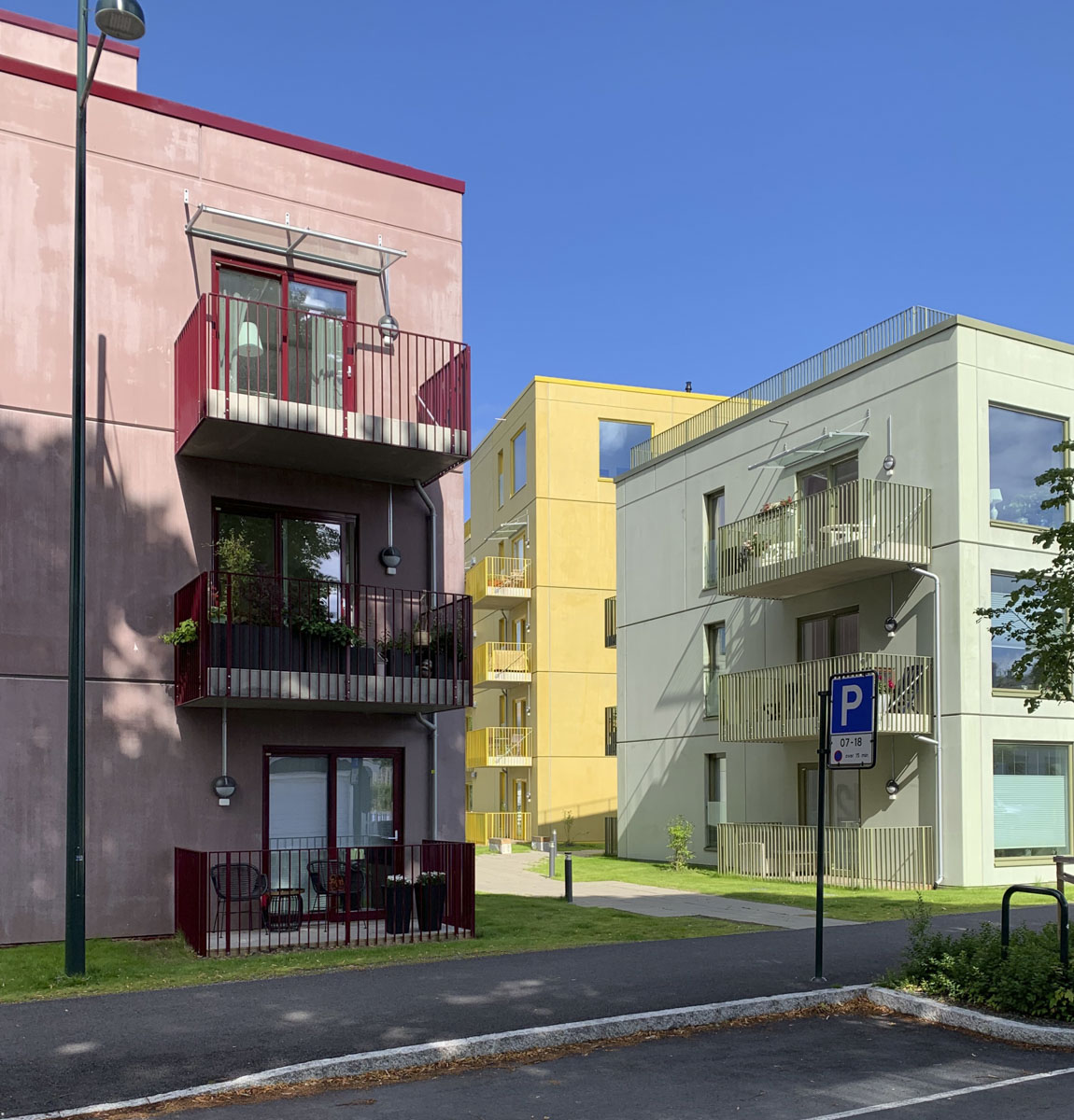 Tre boligblokker i pastellfarger