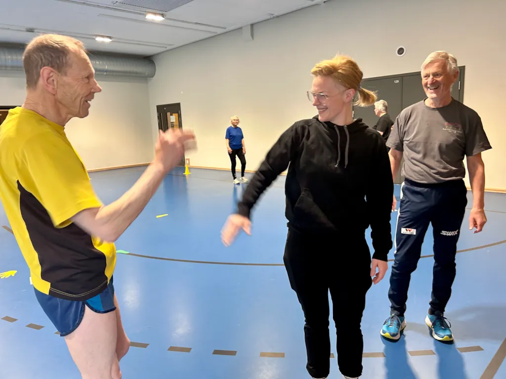 Gruppetrening i Myrahallen. Instruktør gir high-five til en av deltagerne.