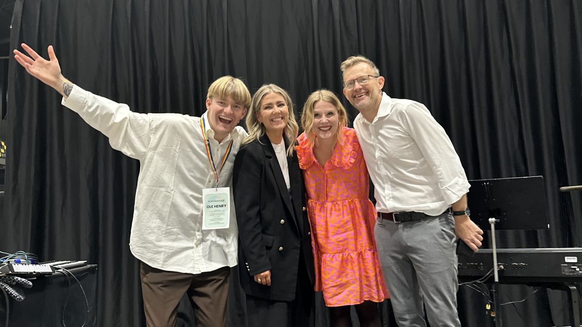 To menn og to kvinner står sammen og smiler mot kamera.