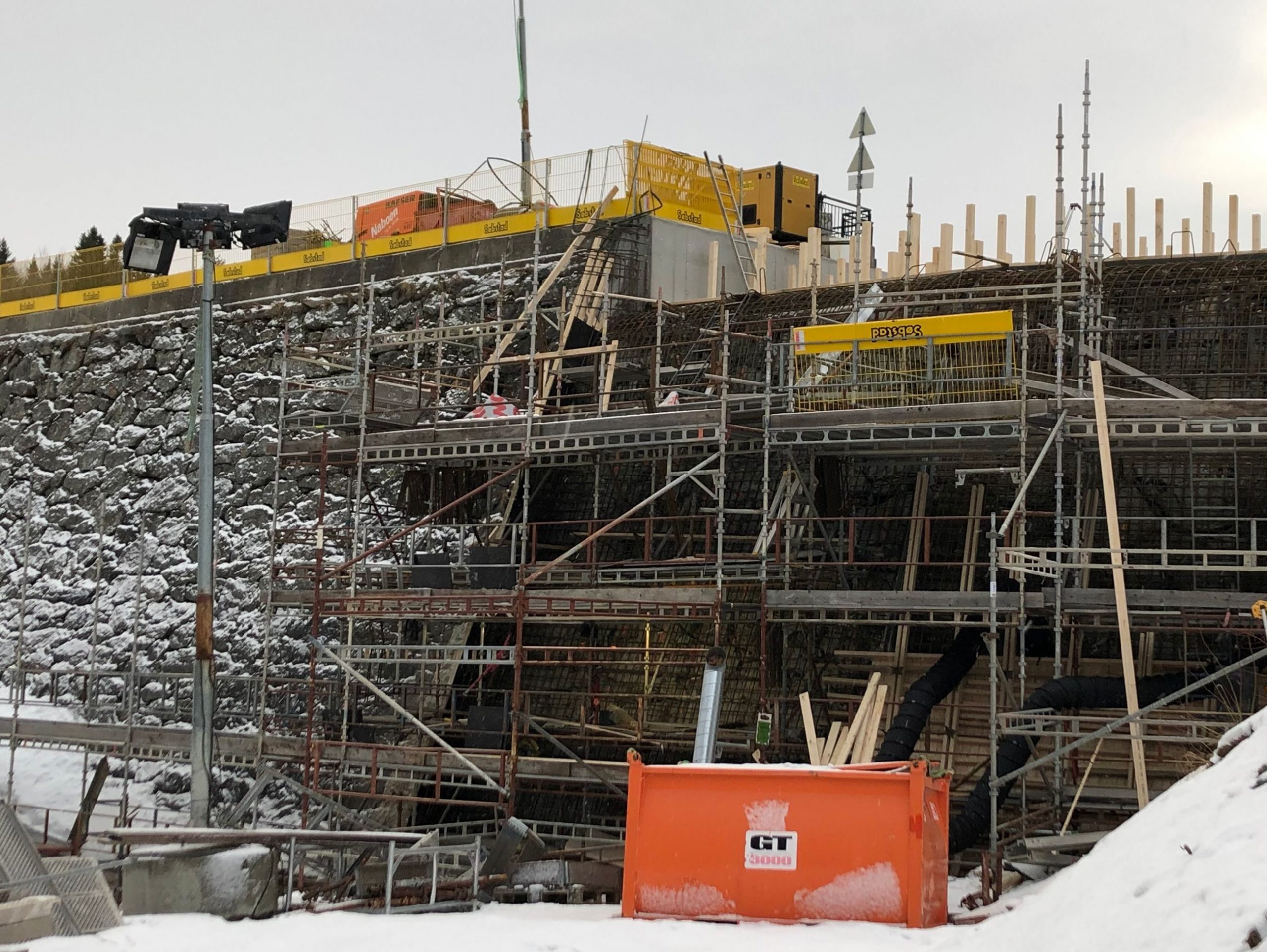 Demning sett fra front med stillas foran