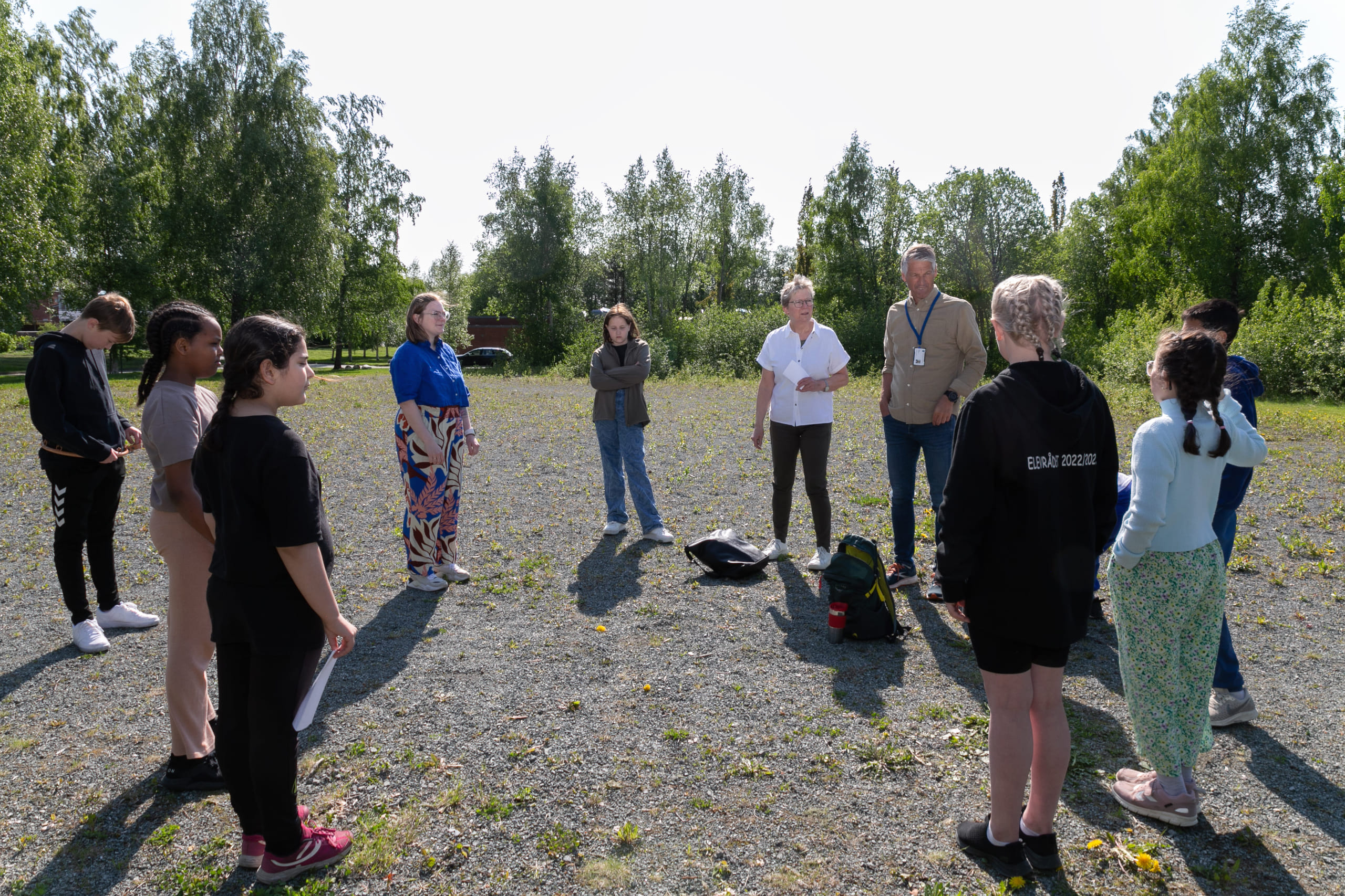Flere personer som st&aring;r p&aring; ei slette og snakker sammen