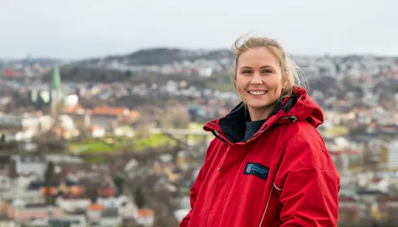 Portrett av koordinerende sykepleier Maren Brønstad, med Trondheim by i bakgrunnen.