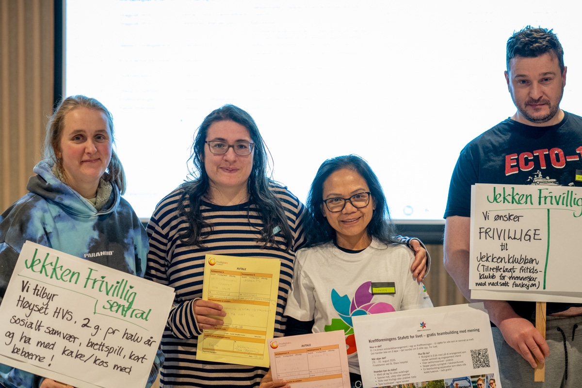 Tre unge kvinner og en ung mann smiler til kamera.