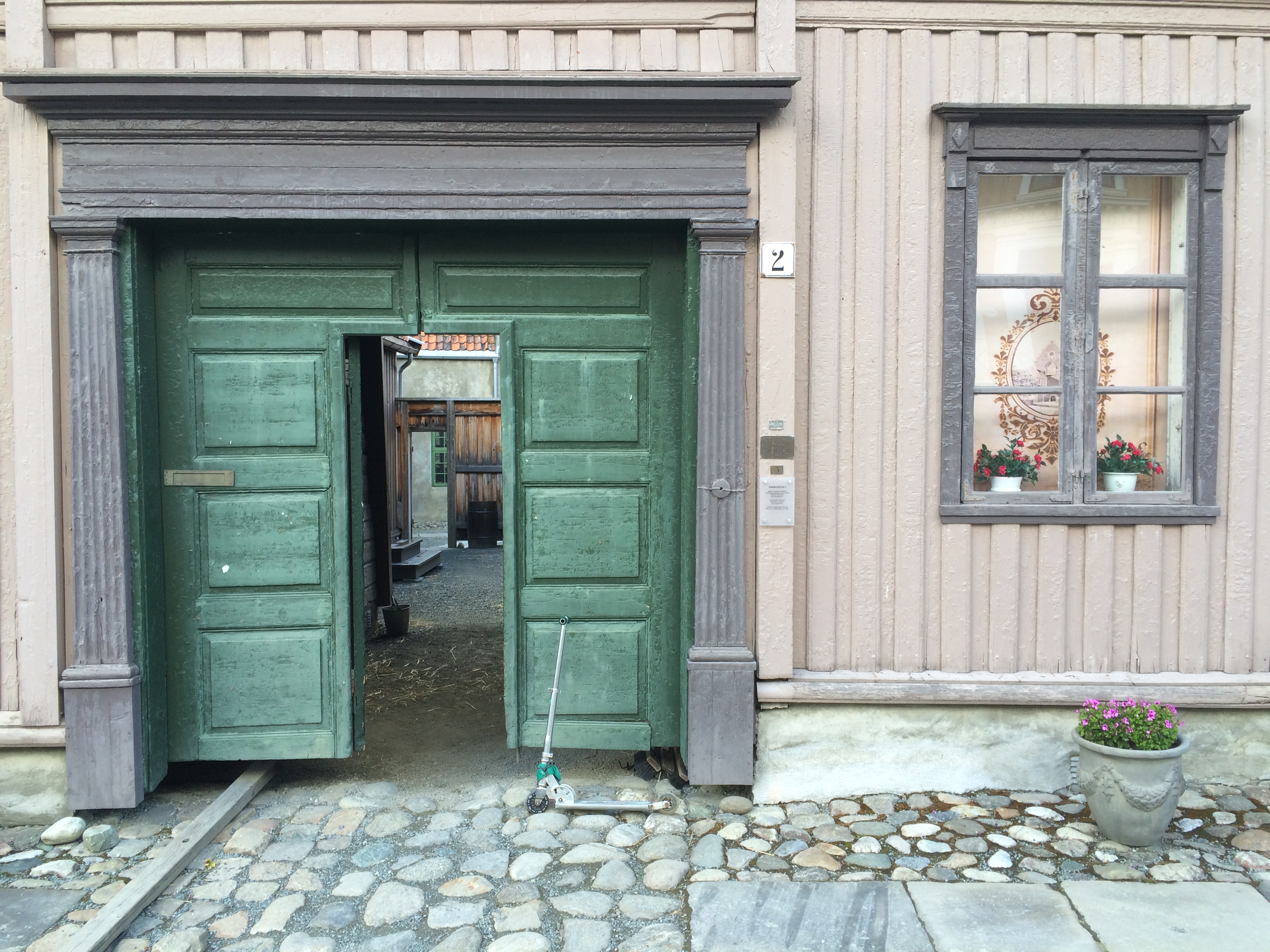 Gr&oslash;nn port med &aring;pen d&oslash;r inn til portrom