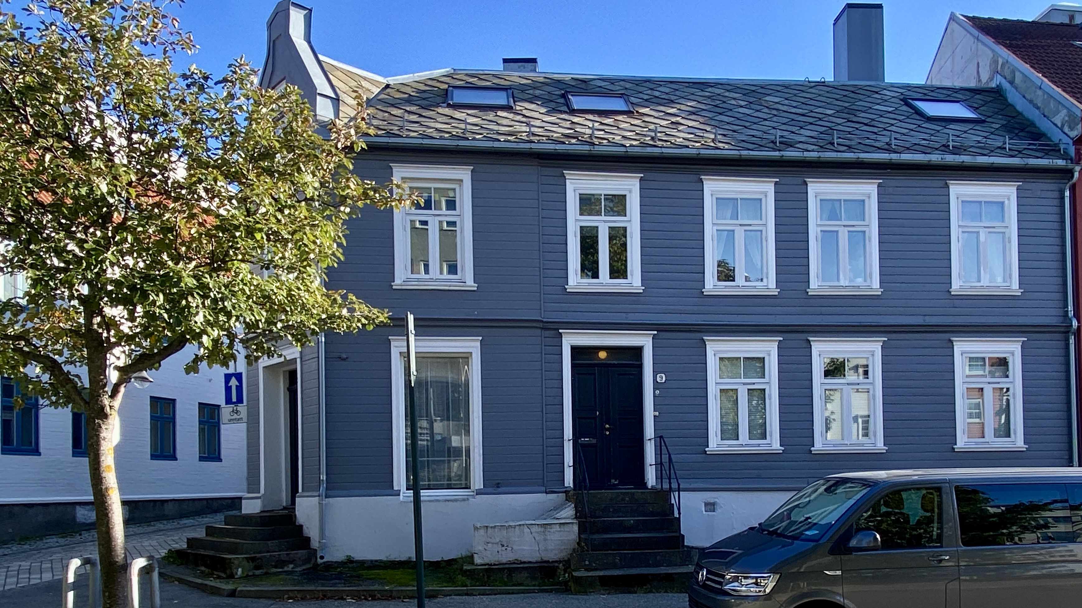 Gr&aring; bygning i to etasjer der del av bygningen er oppf&oslash;rt i mur