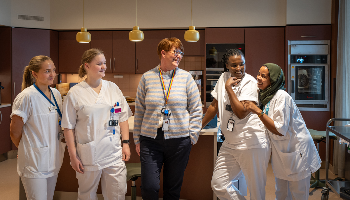 Enhetsleder H&oslash;yset sammen med ansatte