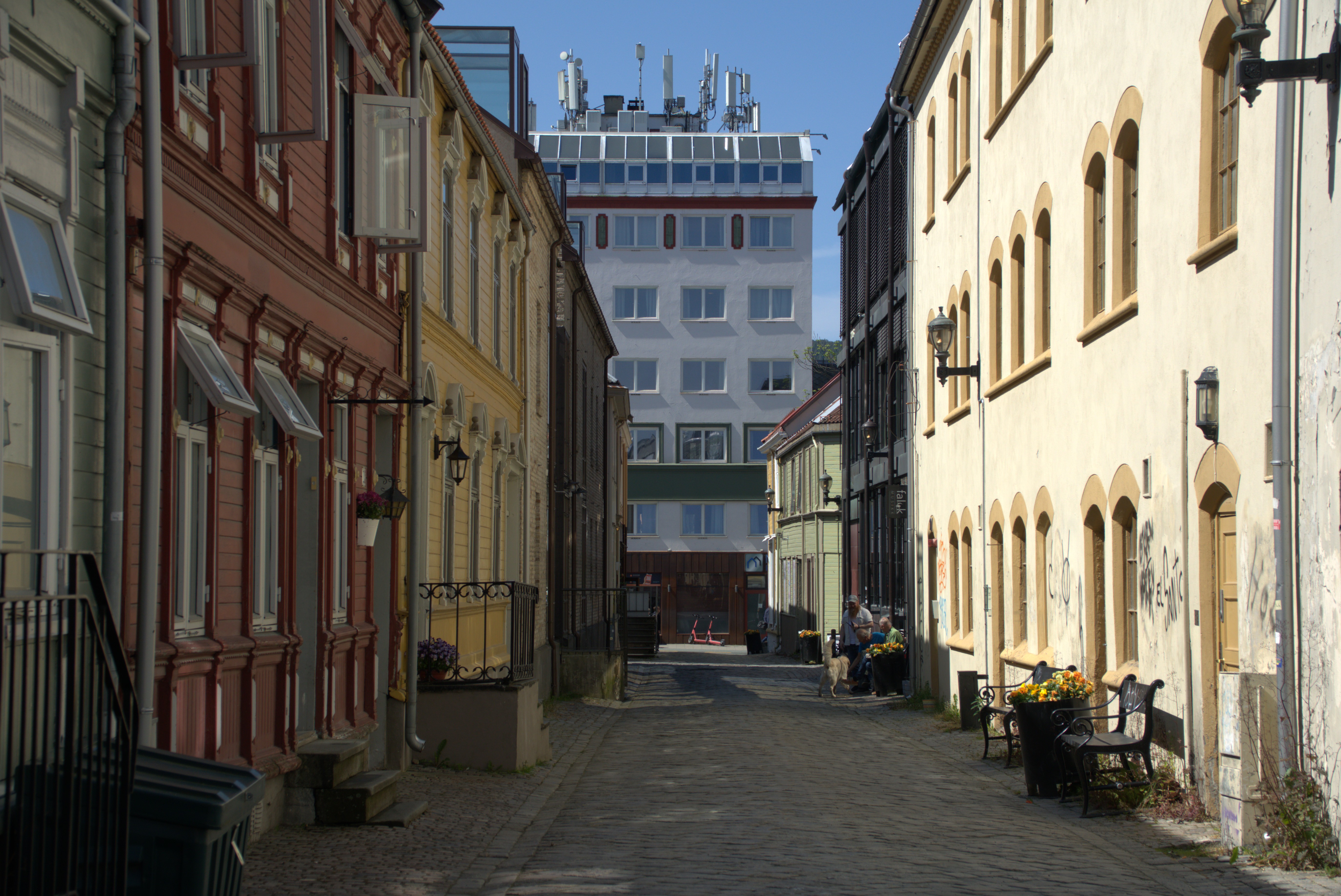 ei smal gate med 2 og 3 etasjer bygninger på hver side