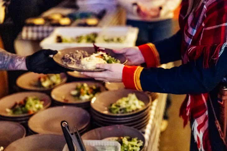 Nærbilde av noen som forsyner seg med mat.