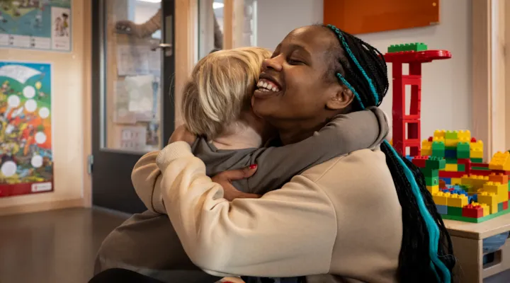 Et barn klemmer praksiskandidat i barnehage