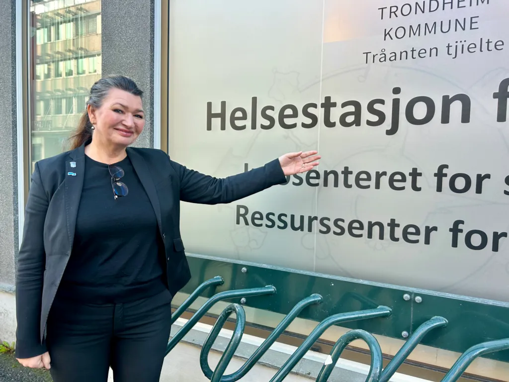 Bildet viser helsebyråd Merethe Ranum peke på et skilt der det står Helsestasjon