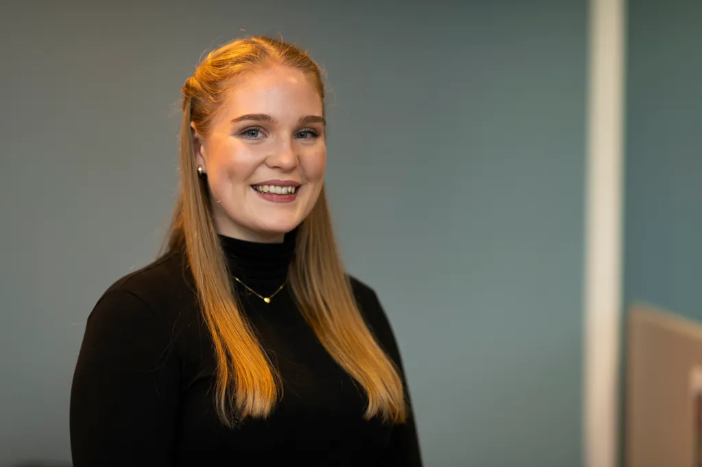 Portrett av Emilie med blågrå bakgrunn.