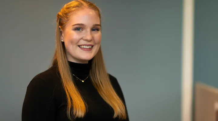 Portrett av Emilie med blågrå bakgrunn.