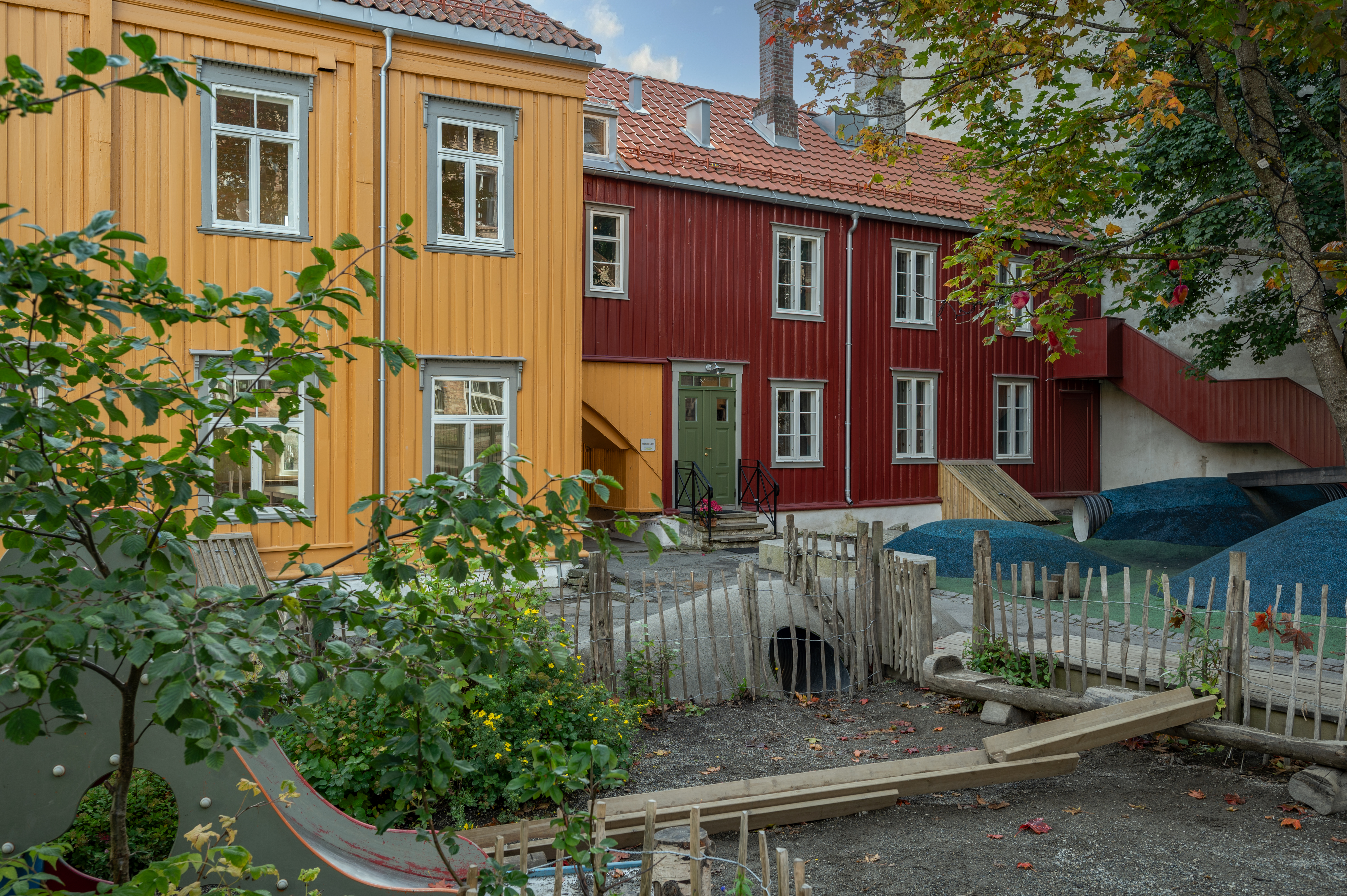 Skolegården med to bygg i bakgrunnen