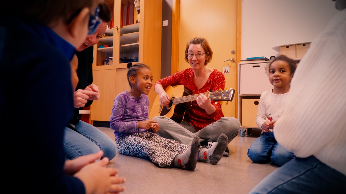 Pedagog spiller gitar for barn
