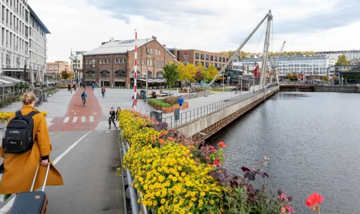 Folk på blomsterbrua og TMV-odden med utsikt mot Solsiden