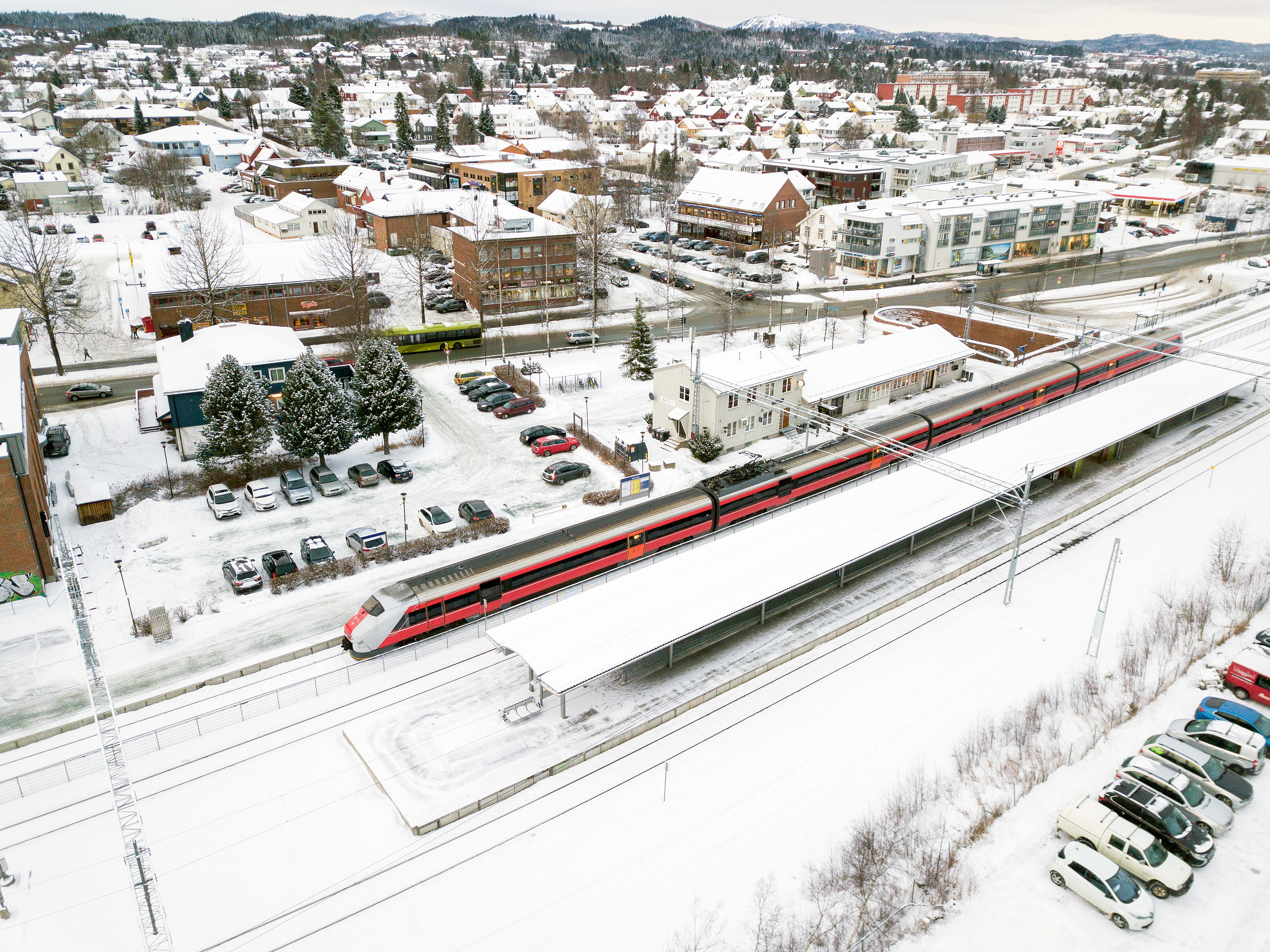 Dronebilde av Heimdal stasjon med togstasjon i fremgrunnen og Heimdal sentrum i bakgrunnen