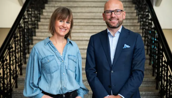 Foto av Michelle Wright og Kristian Dahlberg Hauge stående foran trappen inne i rådhuset i Trondheim
