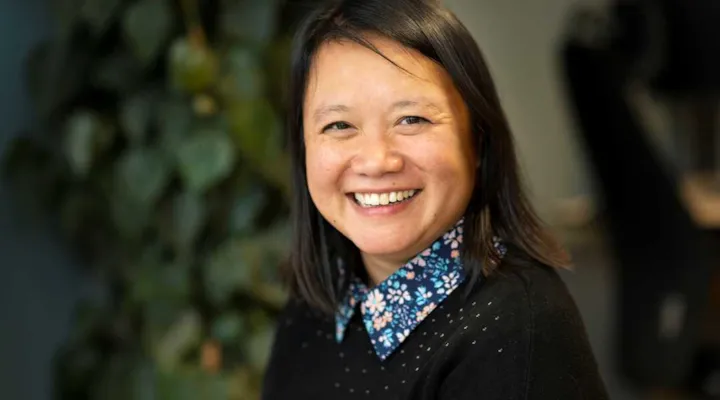 Portrett av avdelingsleder Phuong Pedersen foran en stor plante