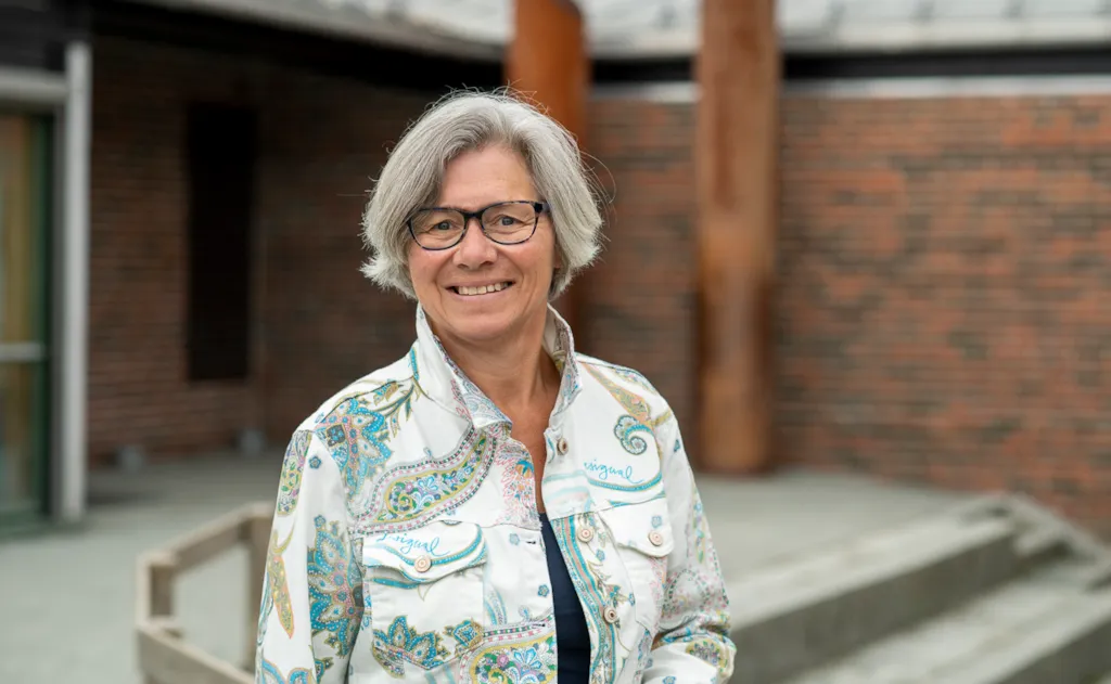 Portrett av rektor Gro Kristiansen foran inngangspartiet til Dalgård skole og ressurssenter.