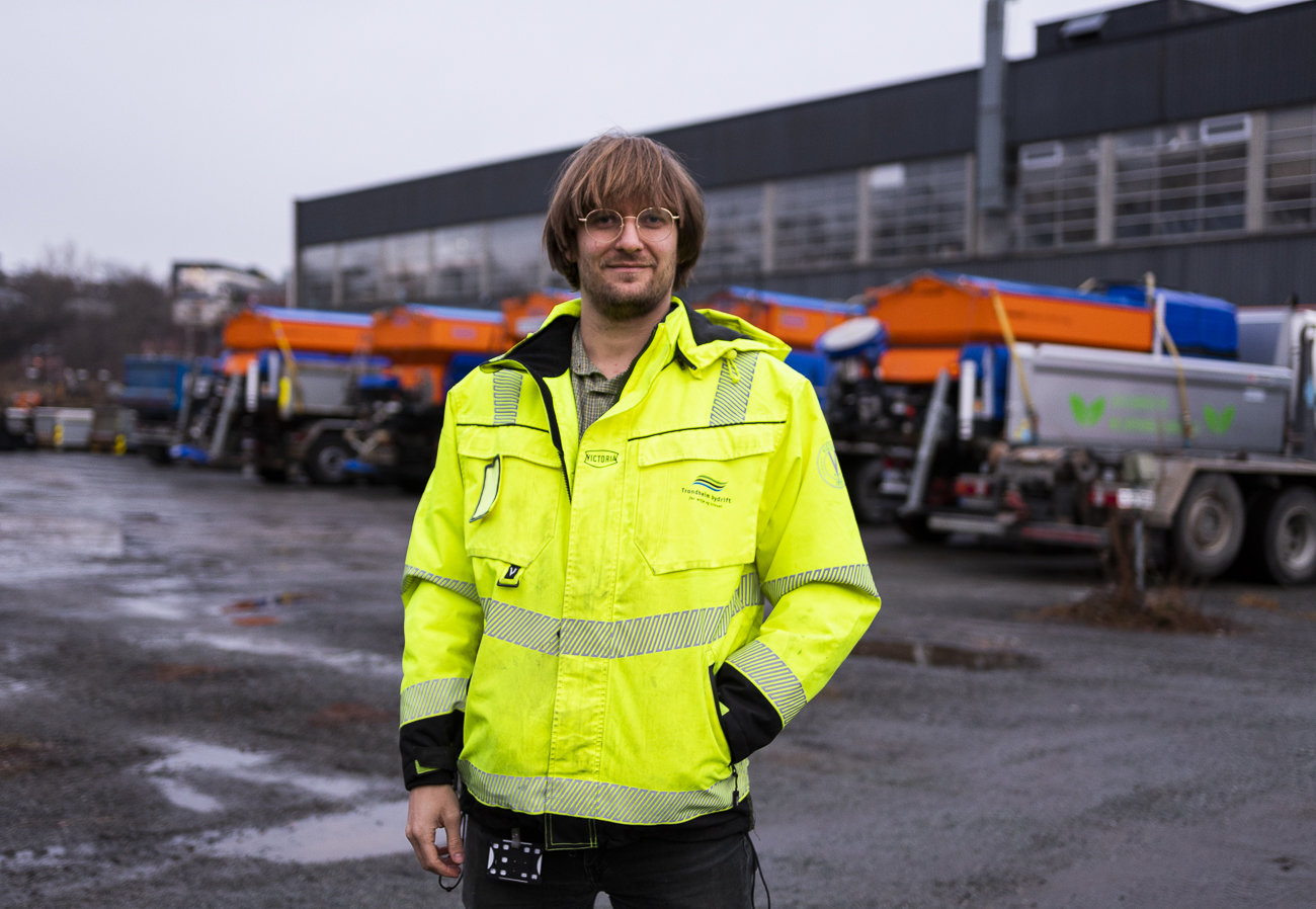 Foto av milj&oslash;r&aring;dgiver Markus Karijord. I bakgrunnen ser vi et garasjeanlegg og noen lastebiler.