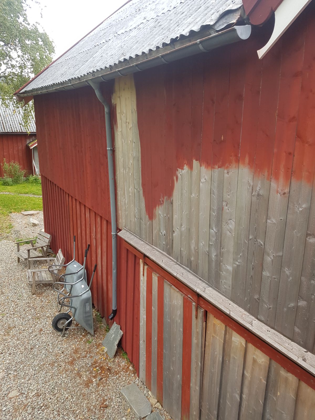 låvevegg delvis uten maling og delvis med rød komposisjonsmaling