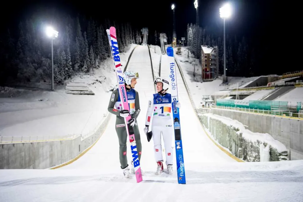 Foto av Johann André Forfang og Eirin Kvandal foran hoppbakkene i Granåsen