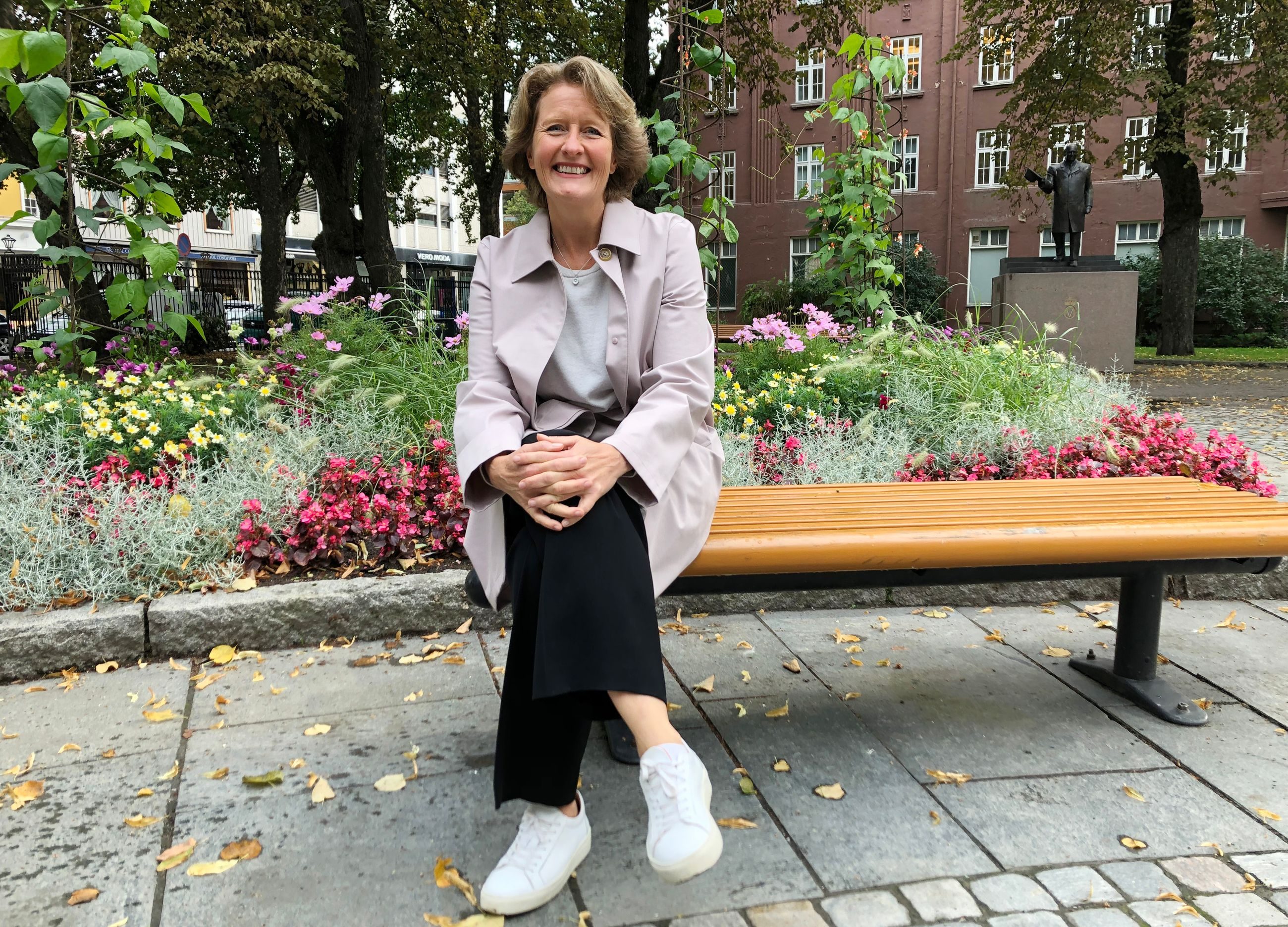 Kvinne sitter p&aring; en benk