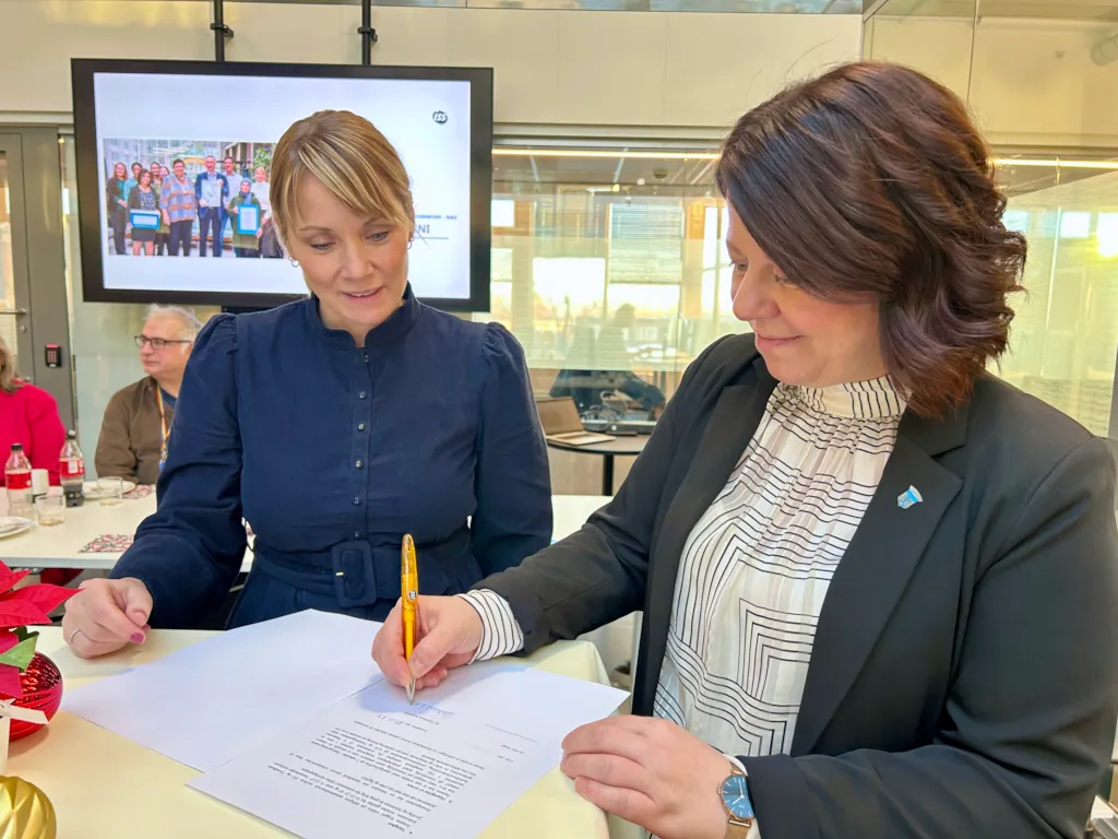 To kvinner signerer en avtale