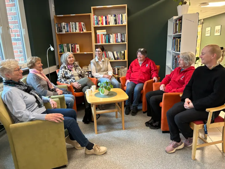 Frivillige ved Søbstad helsehus sitter sammen med prosjektledelseneEn gruppe kvinner sitter sammen amlet i ijen