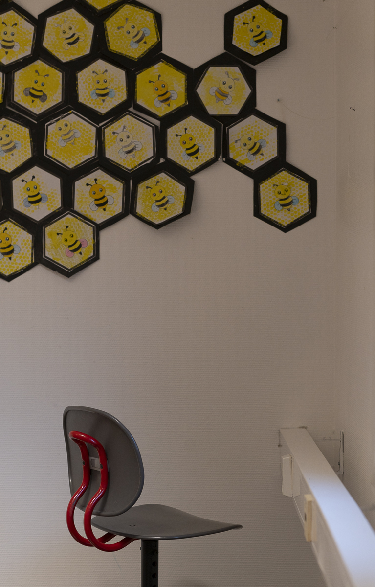 En gr&aring; stol st&aring;r vendt inn mot et hj&oslash;rne.