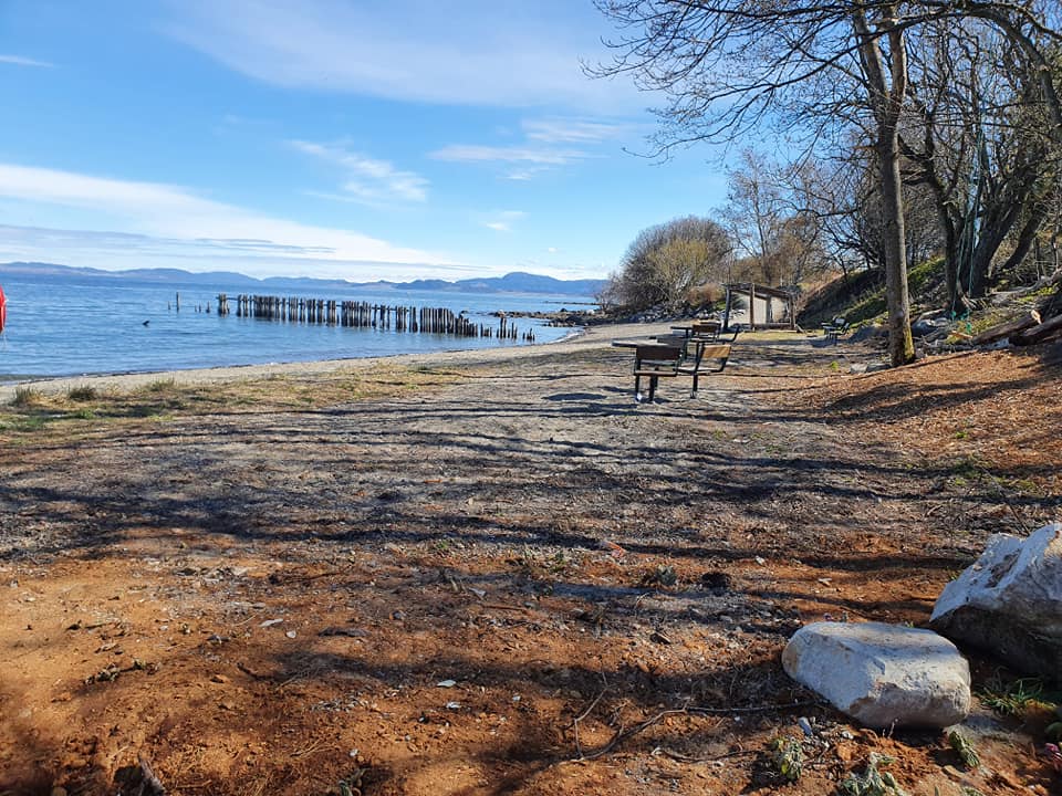 Tømmerstranda ved fjorden med benker og gapahuk