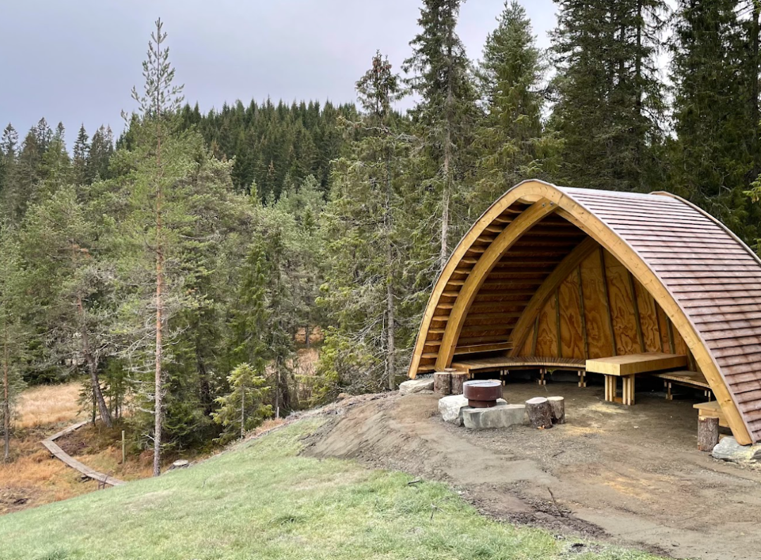 En gamme bygd i tre med bålplass foran