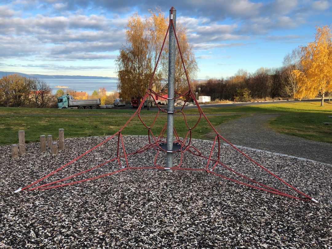 Et klatrestativ med gressplen i bakgrunnen