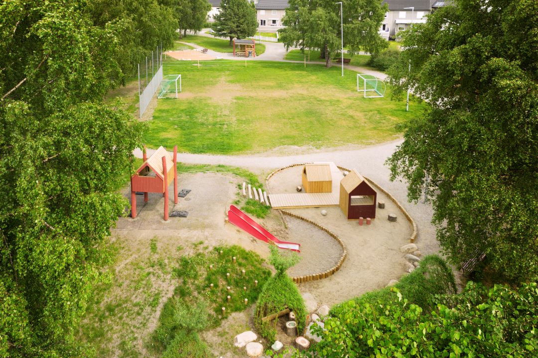 Oversiktsbilde med lekeapparater og fotballbane