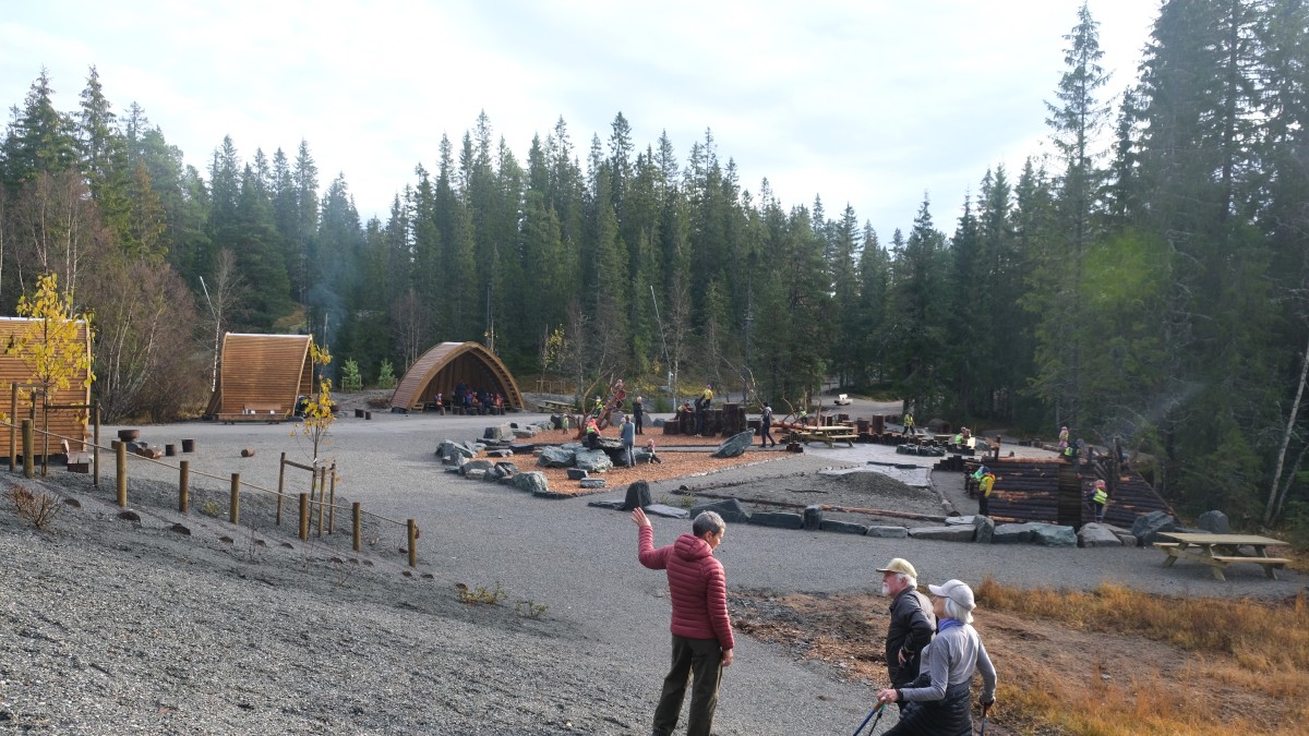Personer i forgrunnen ser mot naturlekeplass