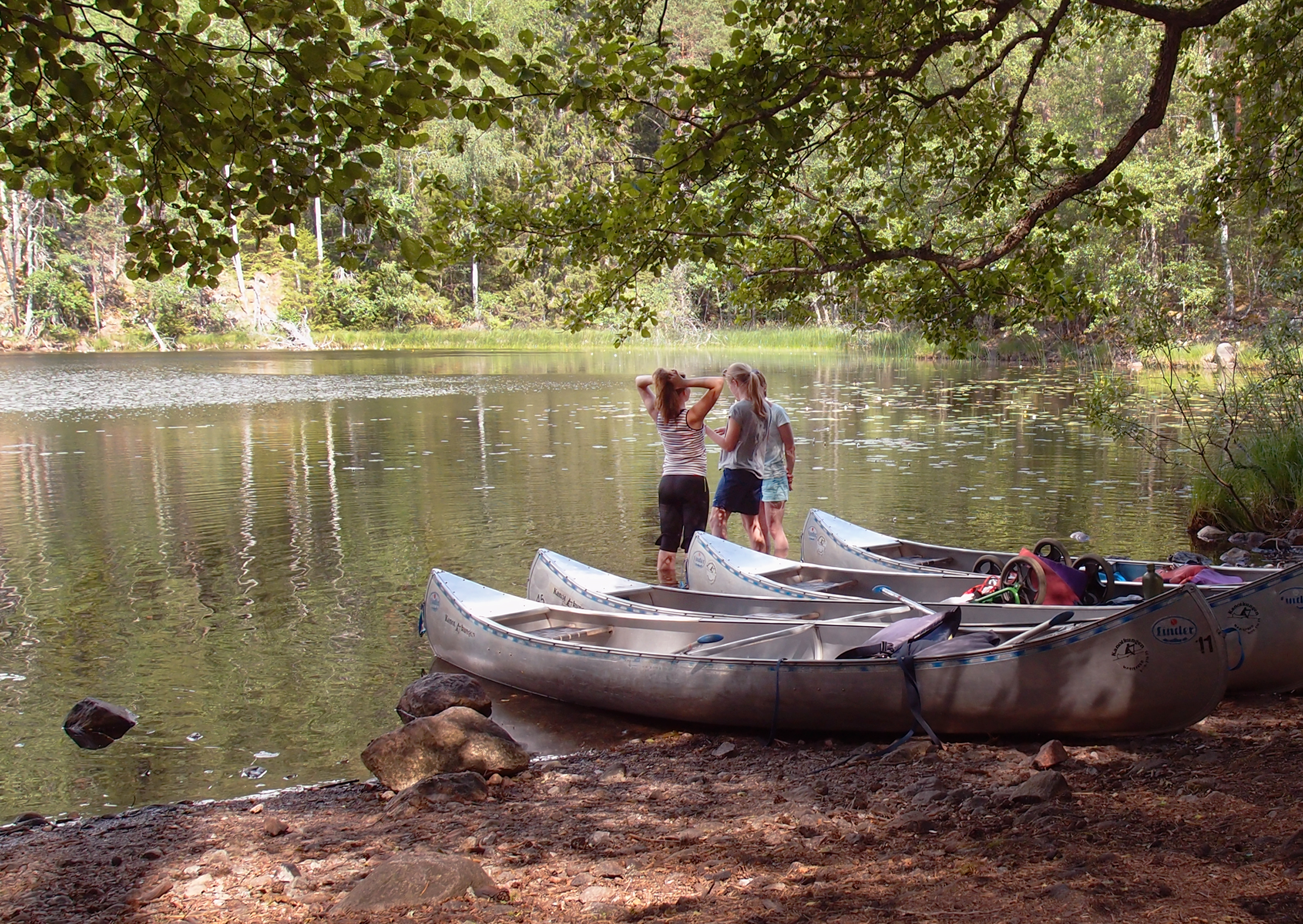 Barn og kanoer ved et vann
